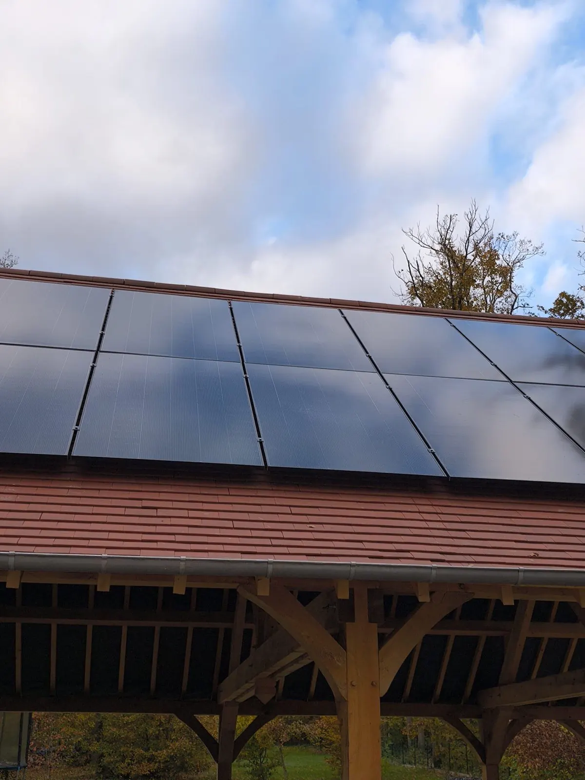 Panneaux solaires posés sur un préau à charpente traditionnelle en chêne, réalisé par JCBO Toit ENR